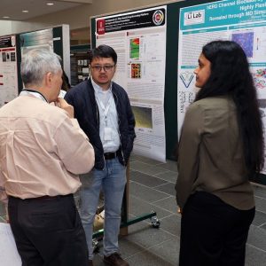 Photo of a student displaying her research poster