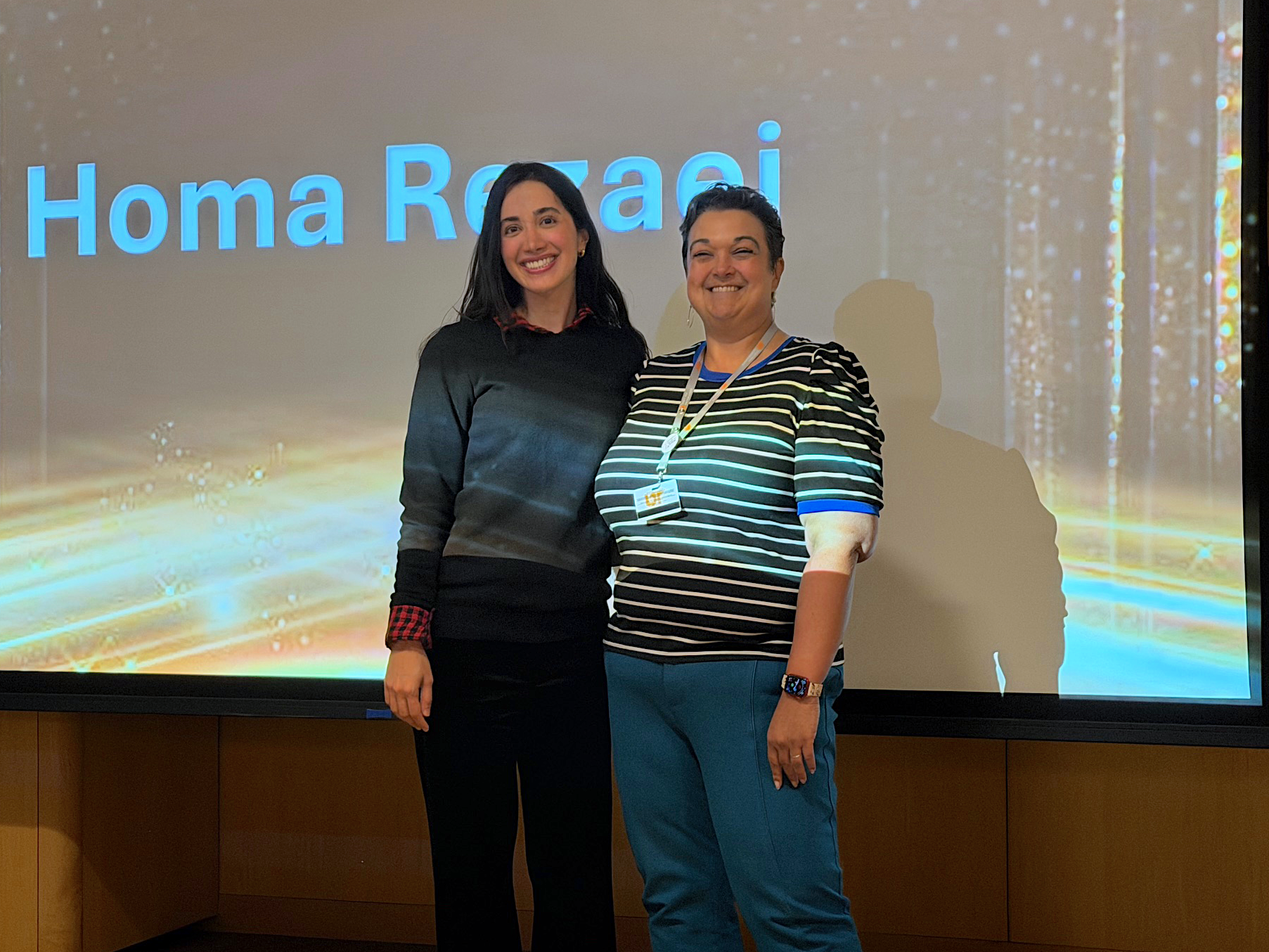 Homa Rezaei and Dr. Snowden posing on stage when Rezaei won