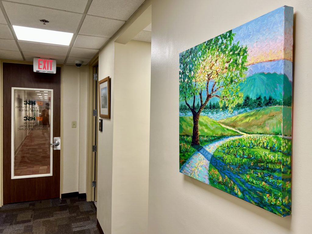 A landscape painting hangs on a wall inside a door