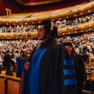 A graduate getting ready to receive her diploma in the auditorium