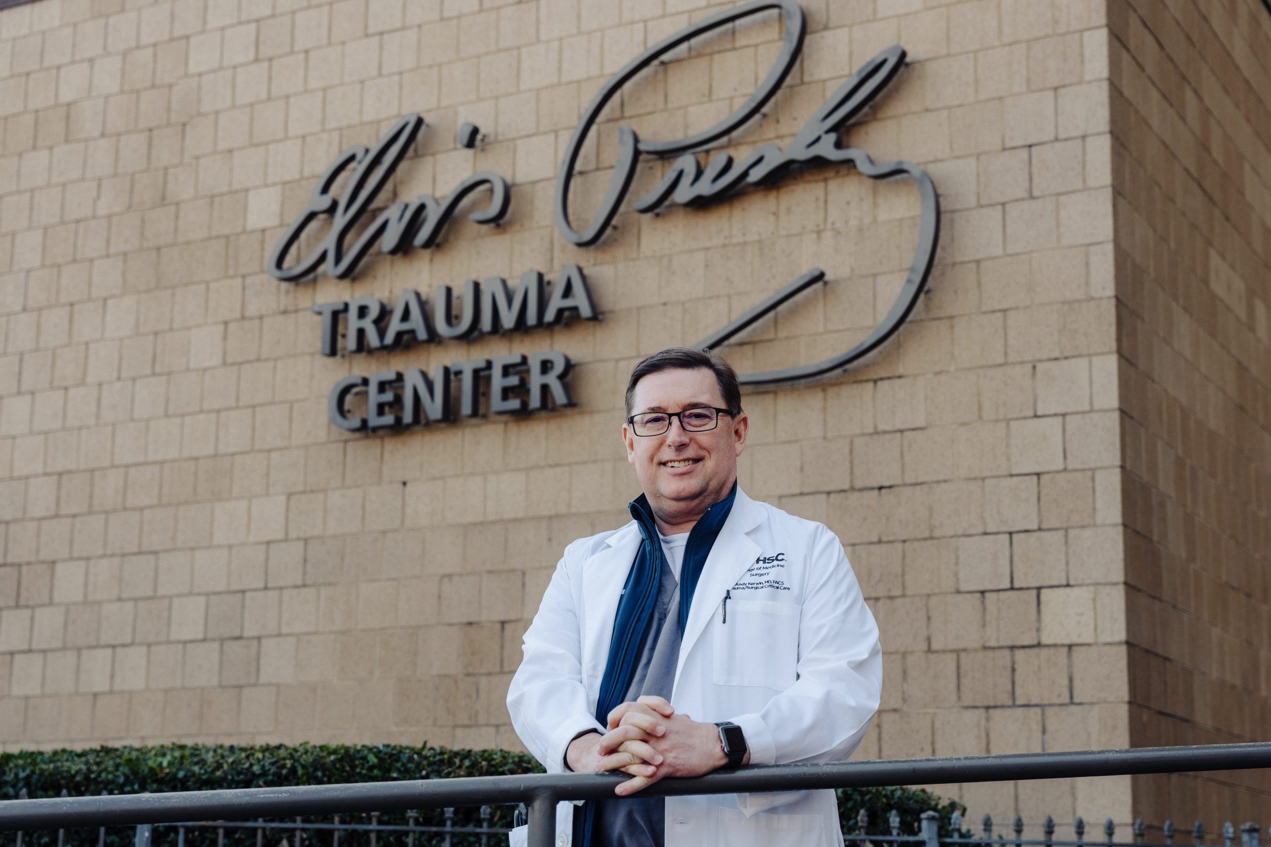 Portrait of Dr. Andrew Kerwin in front of the Elvis Presley Trauma Center sign