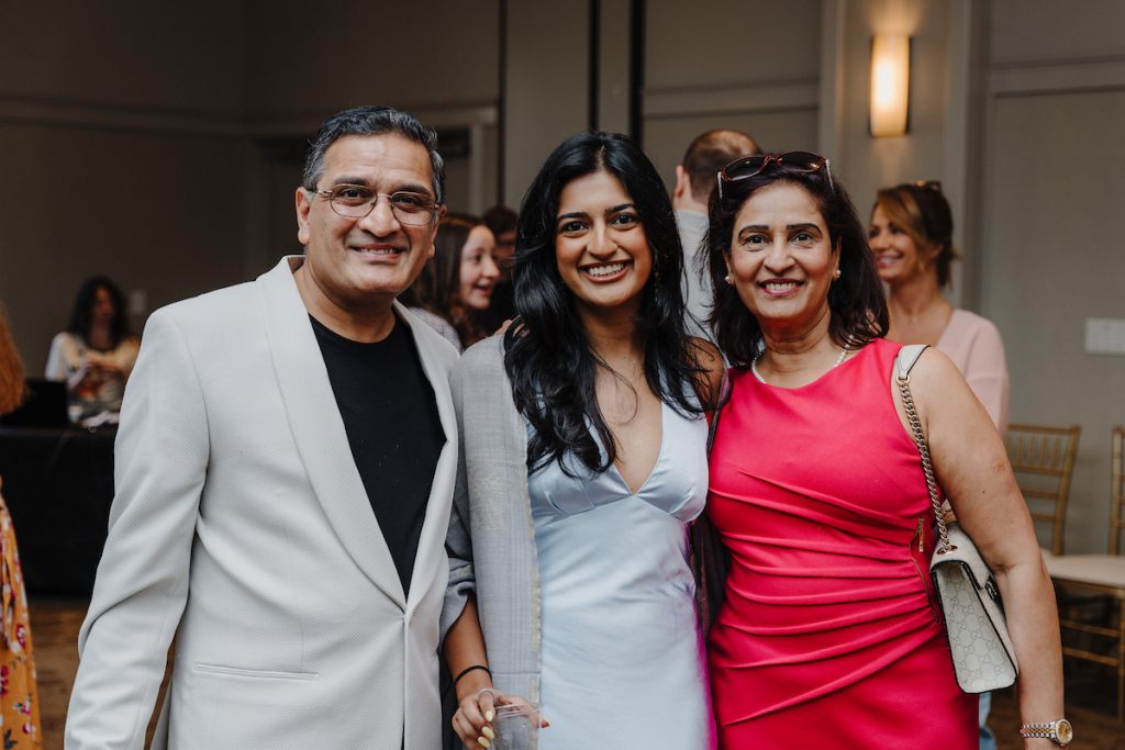 A student and her parents pose for a photo.