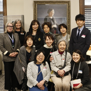 The visitors from Japan gathered with Professors Gill and Langford in front of a portrait of Dr. Newman.