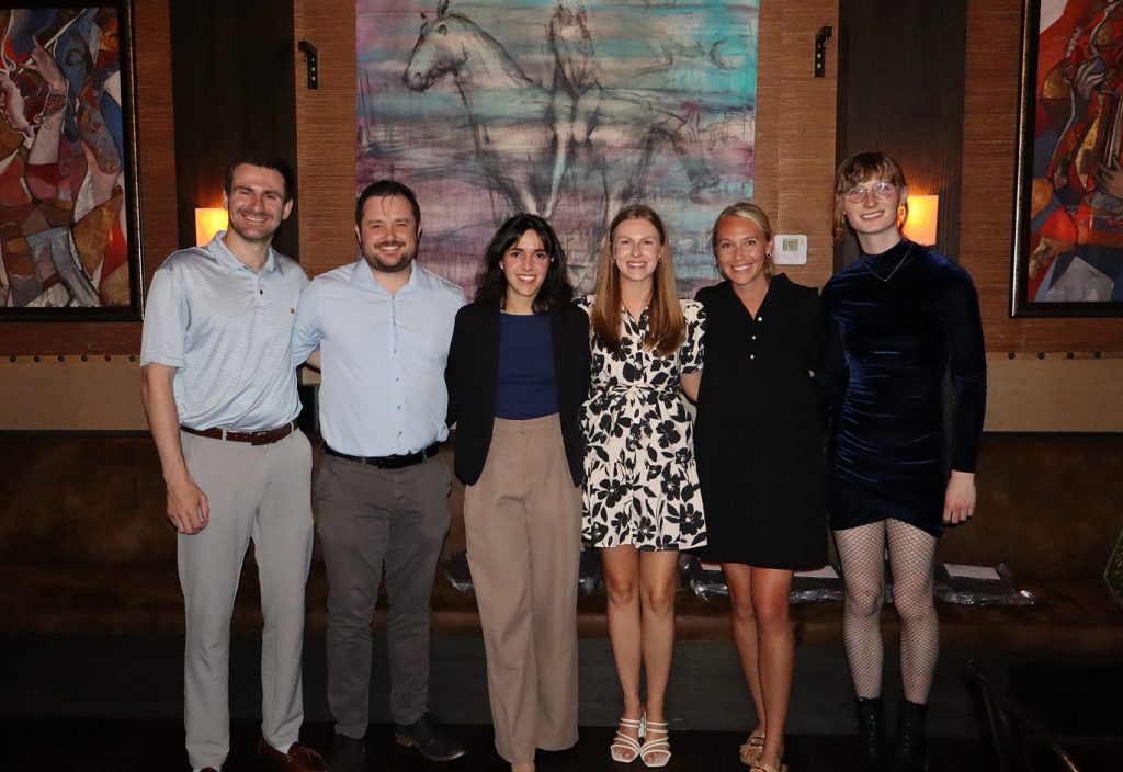 A group of four young women and two young men pose inside in front of a few paintings on Match Day in Chattanooga.