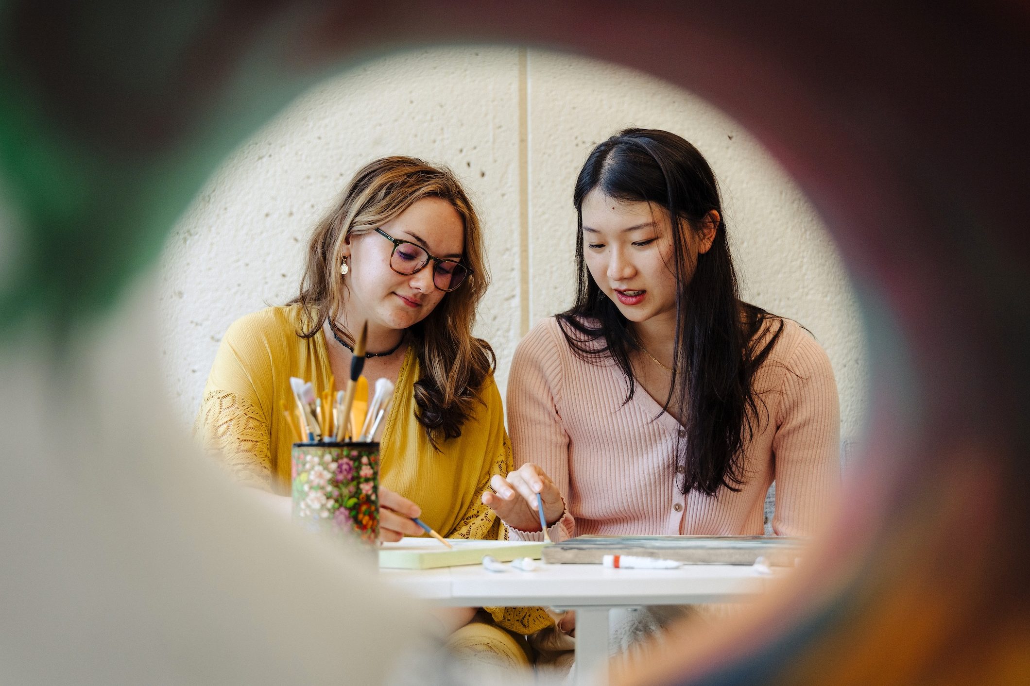 Pepper Mason and Emily Lu working together on a painting.