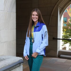 Lexi Duscher in her scrubs with a marathon medal around her neck.
