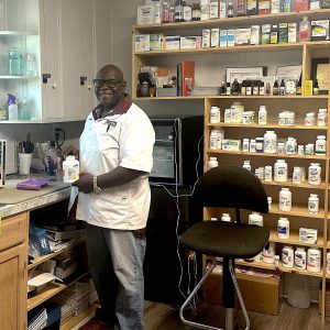 Shawn Pruitt at work in his pharmacy, surrounded by medical bottles and supplies.