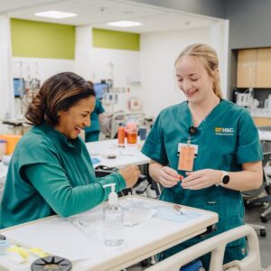 A nursing instructor working with a BSN student in the simulation lab